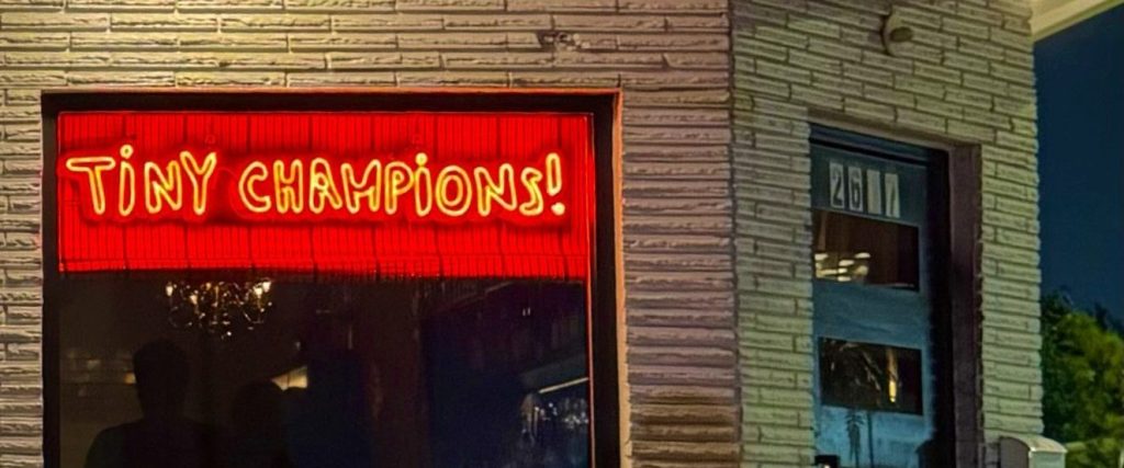 Exterior of Tiny Champions in East Downtown Houston, its red neon sign glowing in the front window